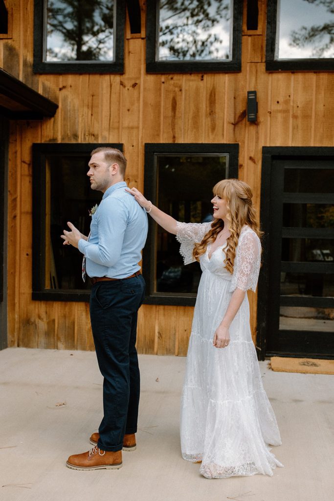 Bride putting her hand on groom during first look
