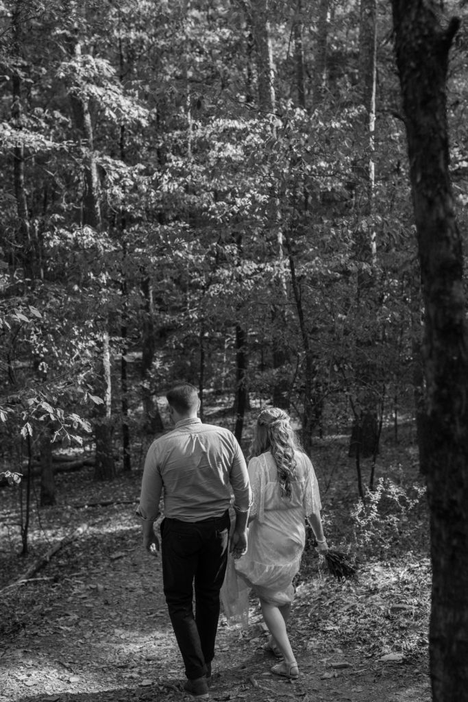Bride and groom hiking on elopement wedding day near Hochatown