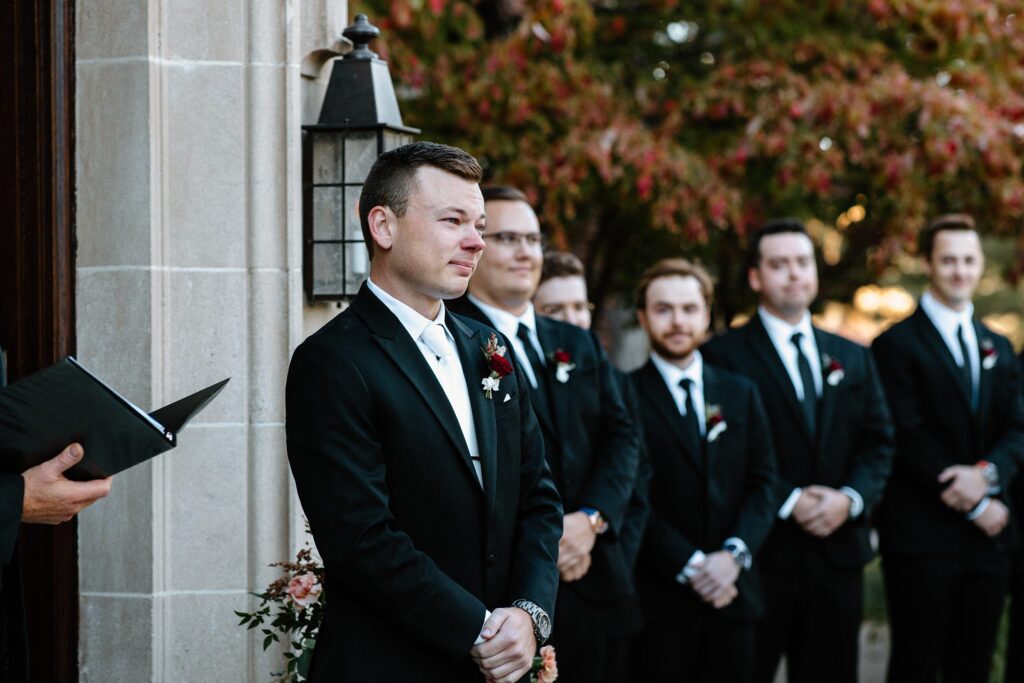 Groom standing at the altar watching bride walk down the aisle 