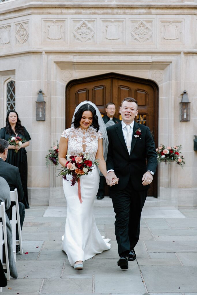 Bride and groom walking down the aisle after outdoor wedding ceremony at Harwelden Mansion