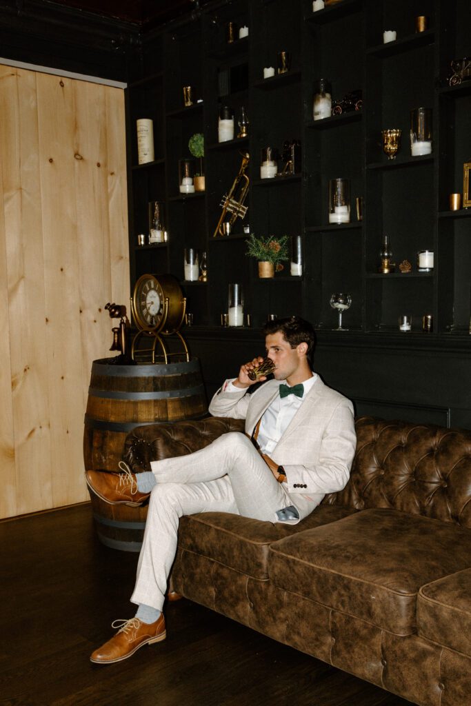 Groom sitting on a couch having a drink