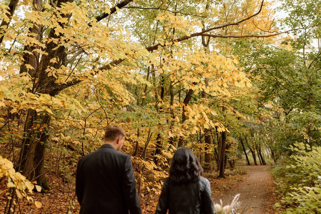 Bride and groom walking in the trail of the woods during mountain elopements