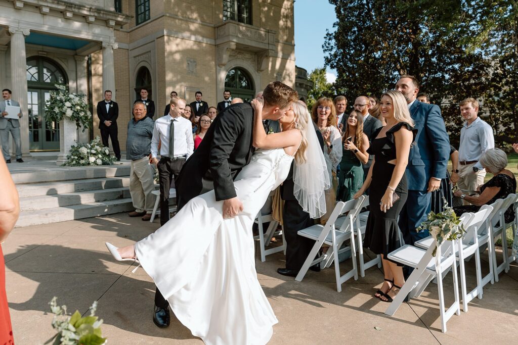 Bride and groom kissing at the end of the aisle during Mansion at Woodward Park wedding outdoor ceremony
