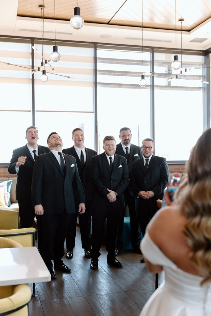 Bride icing the groomsmen during first look
