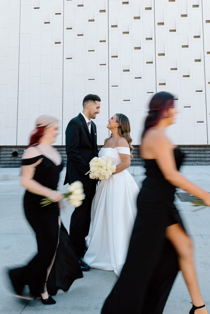 Modern couple portrait with bridal party walking