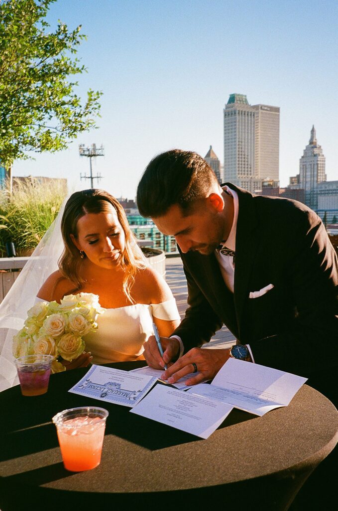 Bride and groom signing their marriage license, film photography