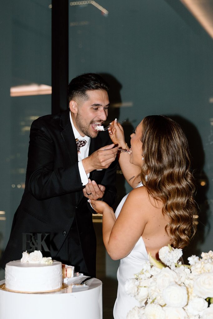 Couple cutting their wedding cake during Tulsa wedding reception at The Vista at 21