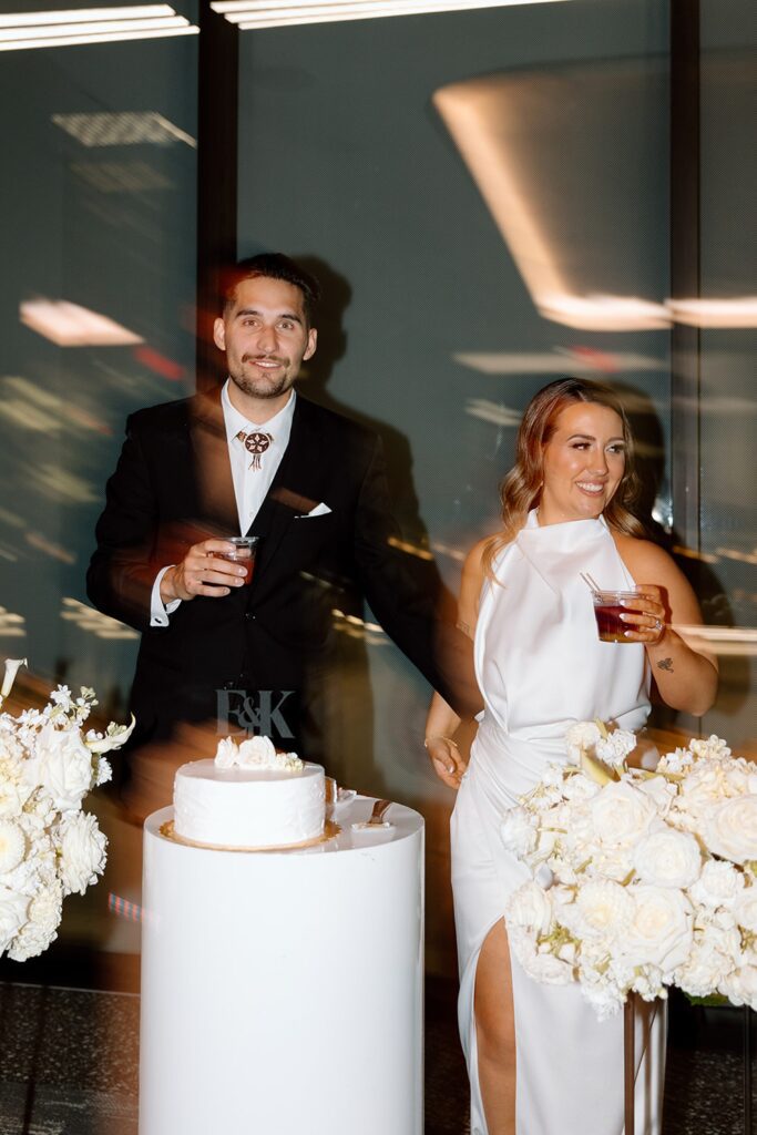 Blurry and in motion photo of couple cutting their wedding cake during Tulsa wedding reception at The Vista at 21