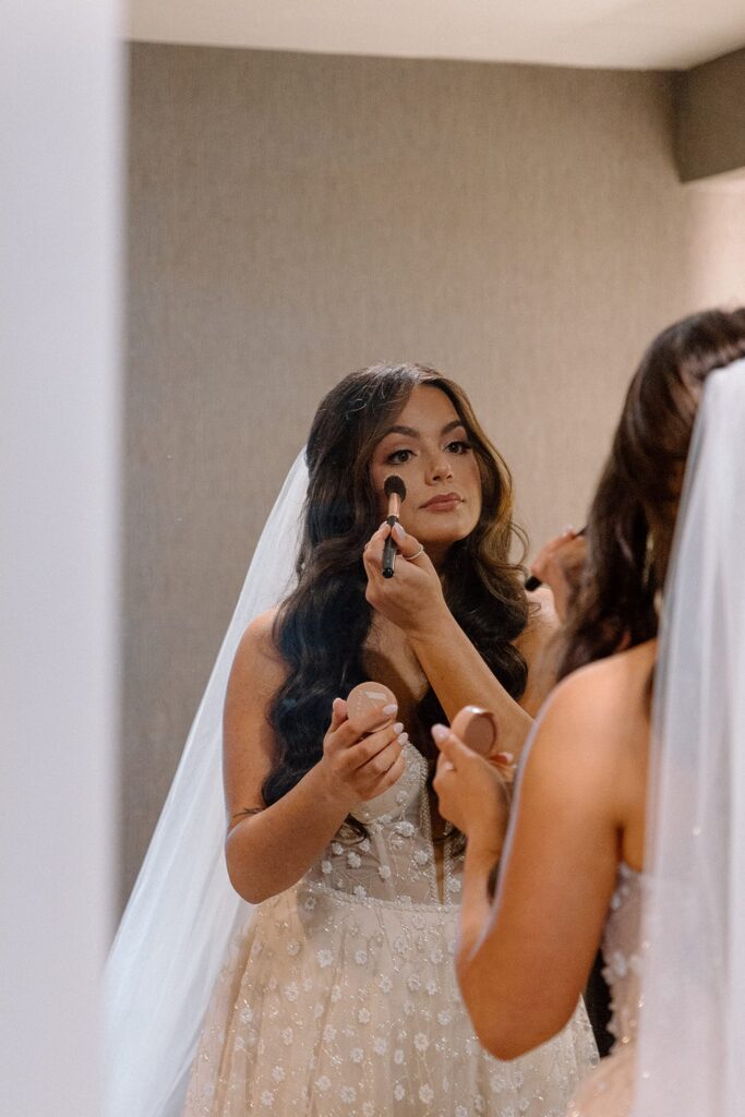 Bride putting on blush for intimate chapel wedding