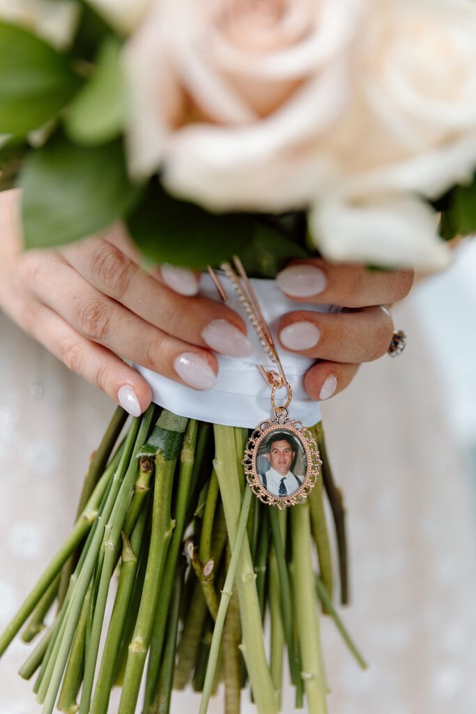 Bridal bouquet with photo charm of loved ones who have passed away 