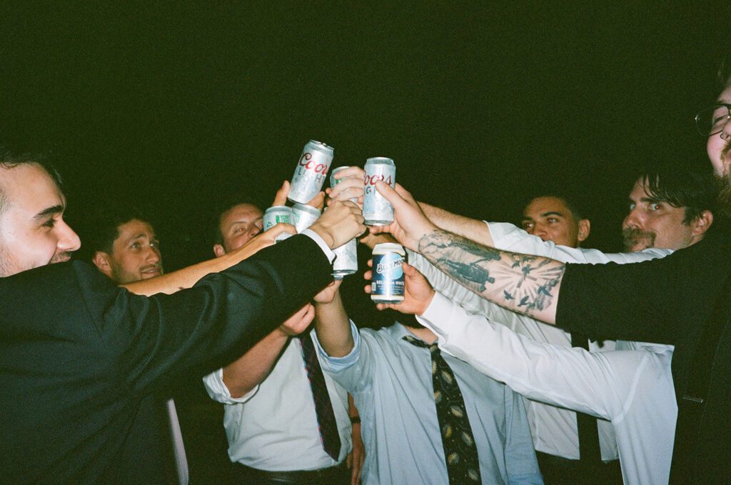 Film photography of men cheerings with beers