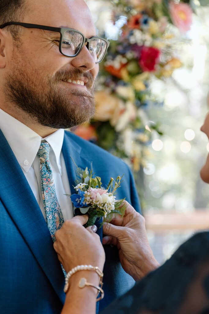 groom smiling getting boutonnieres 