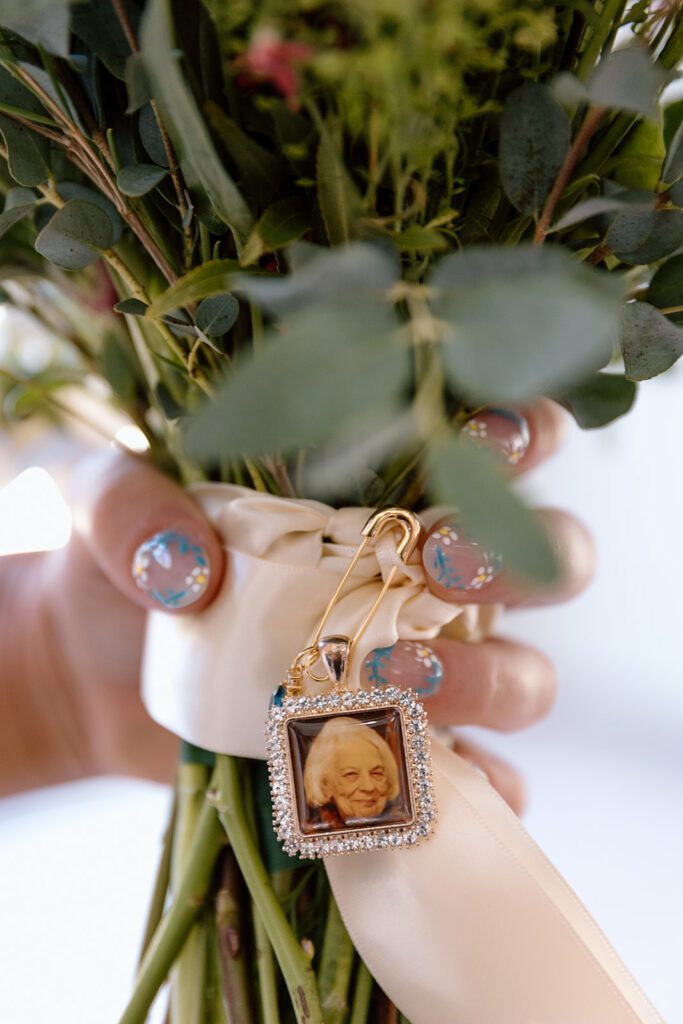 bridal bouquet with grandmother's picture pinned and bridal floral nails 