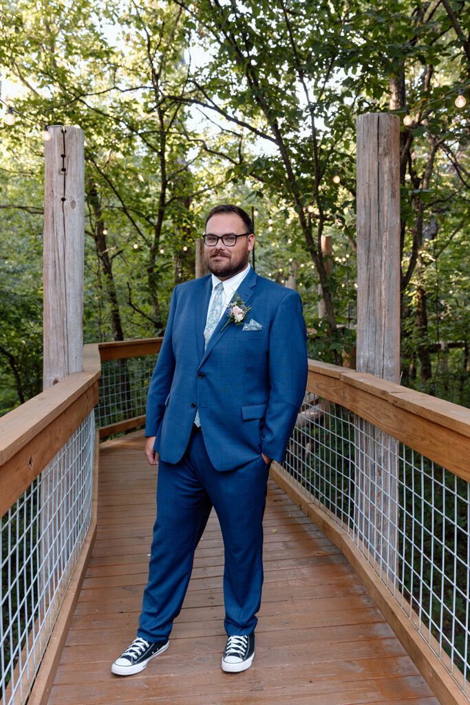 groom on bridge in woods 