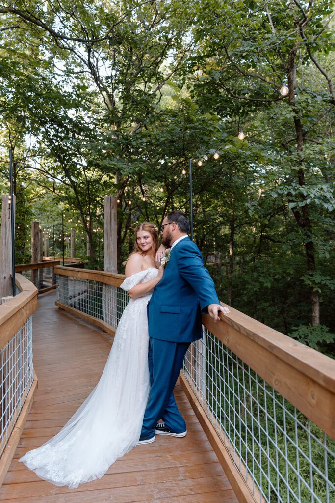 bride and groom under twinkle lights in woods 