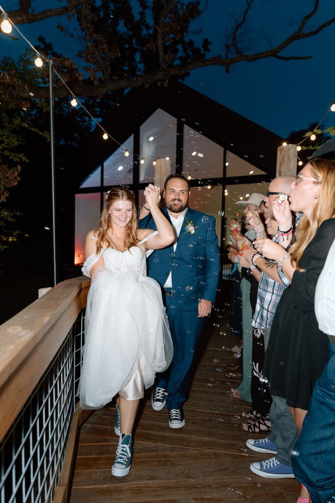 bride and groom exit under twinkle lights 