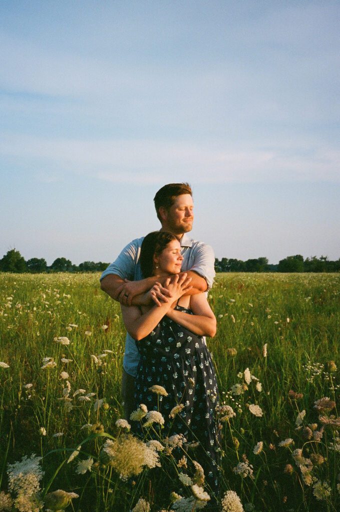 couple hugging golden hour wildflower field 