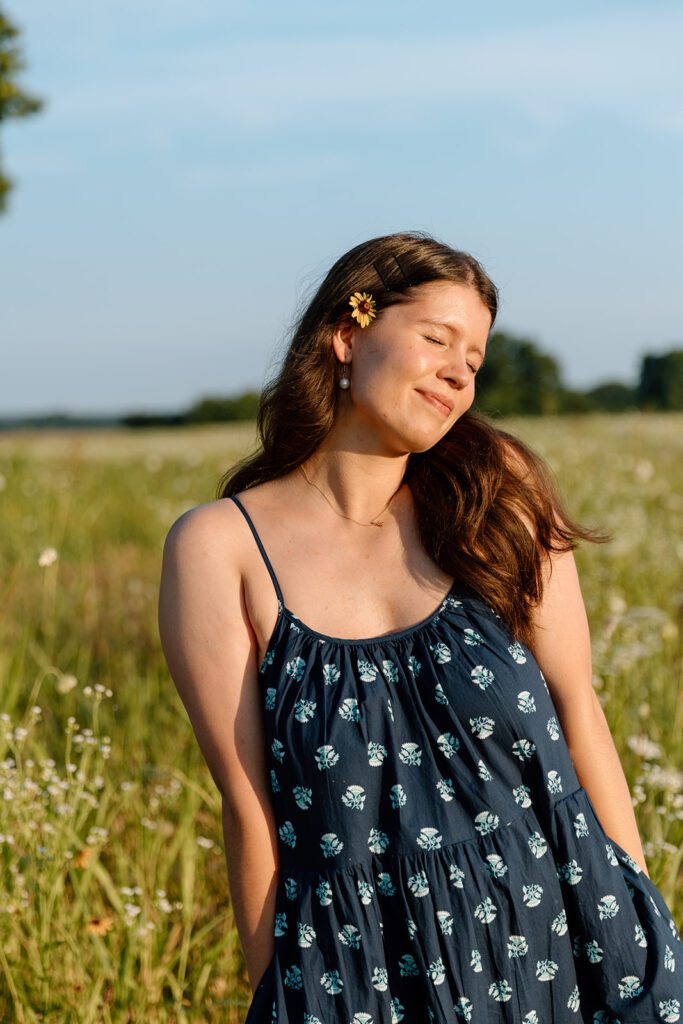 woman in field with flower in their hair