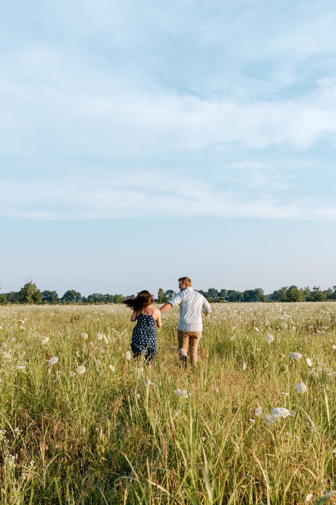 couple running in wildflower field 