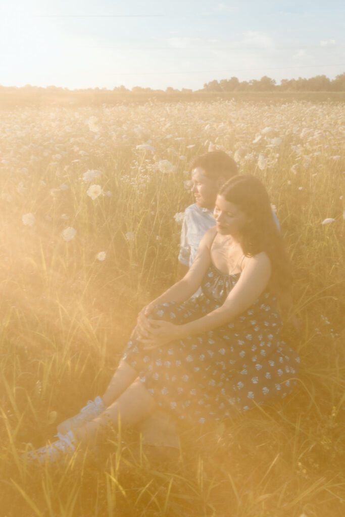 hazy, sunny queen Anne's lace field with couple sitting 