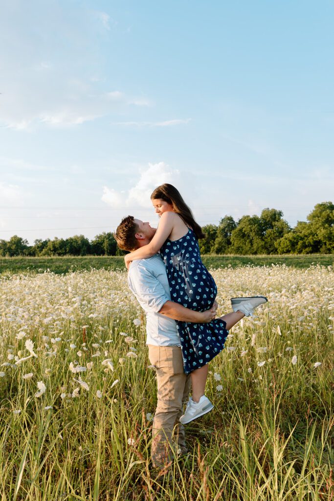 man carrying woman looking at each other in wildflower field 