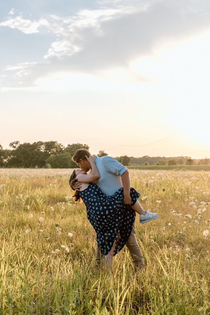 man dipping woman into a kiss in queen Anne's lace wildflower field 