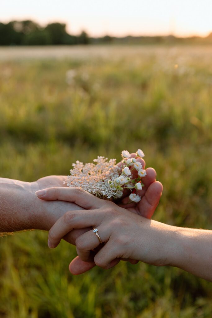 man and women holding hands at wildflower engagement session 