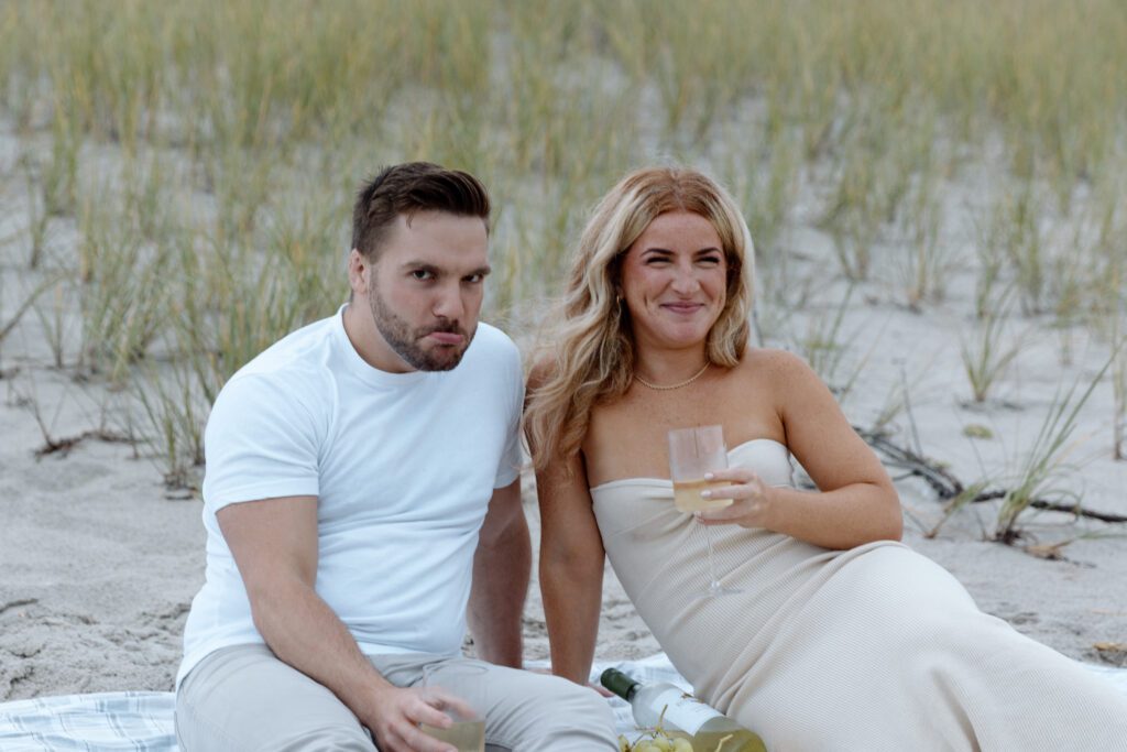 couple being silly at beach picnic 