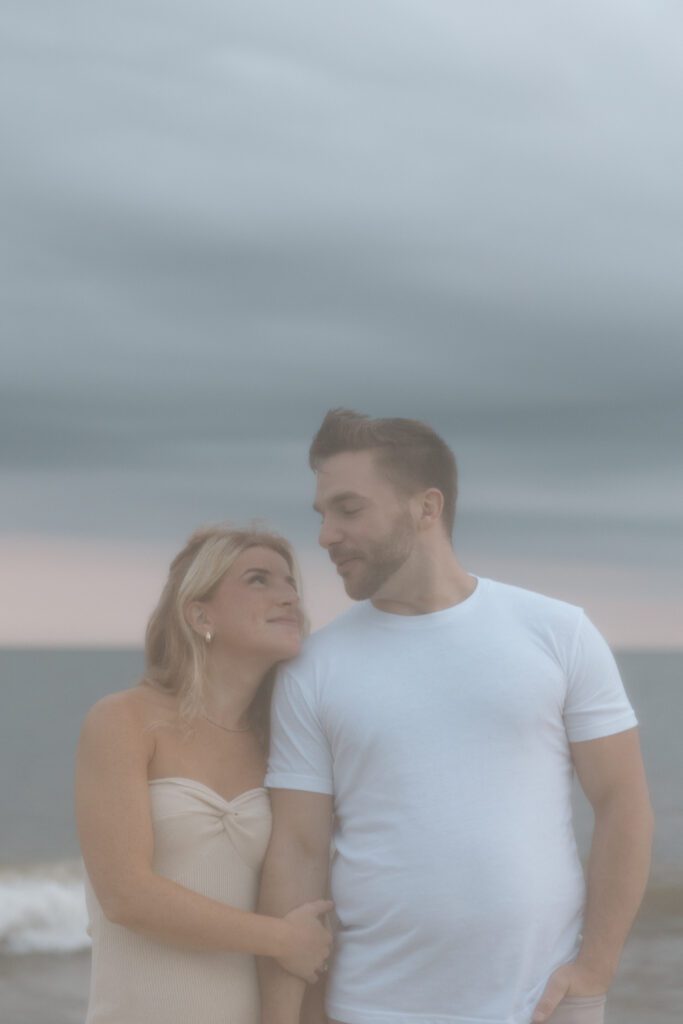 couple staring at each other in front of beach