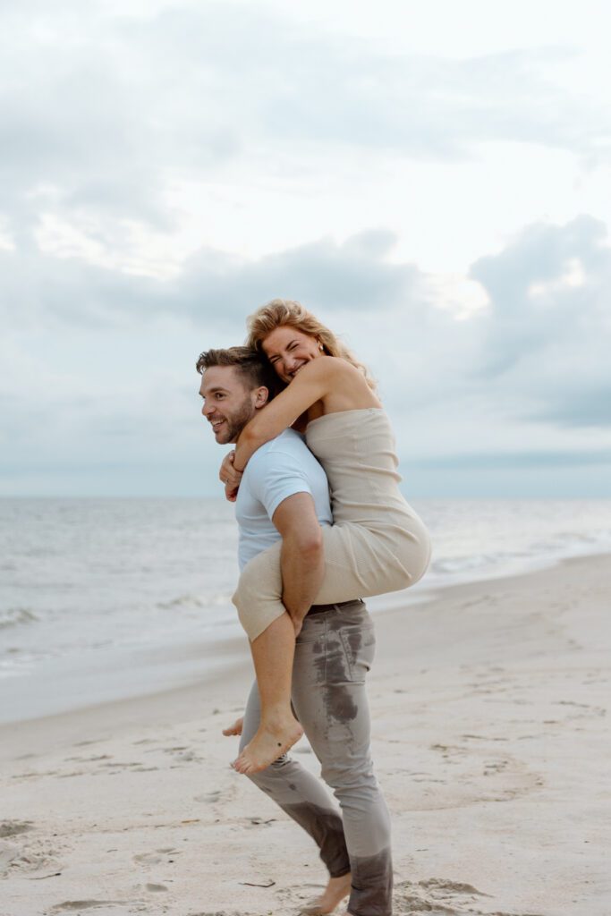 man carrying women on his back on the beach 