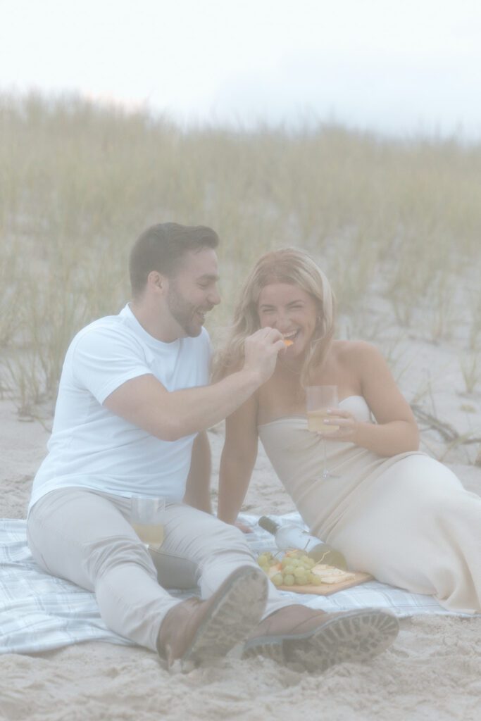 man feeding women at beach picnic 