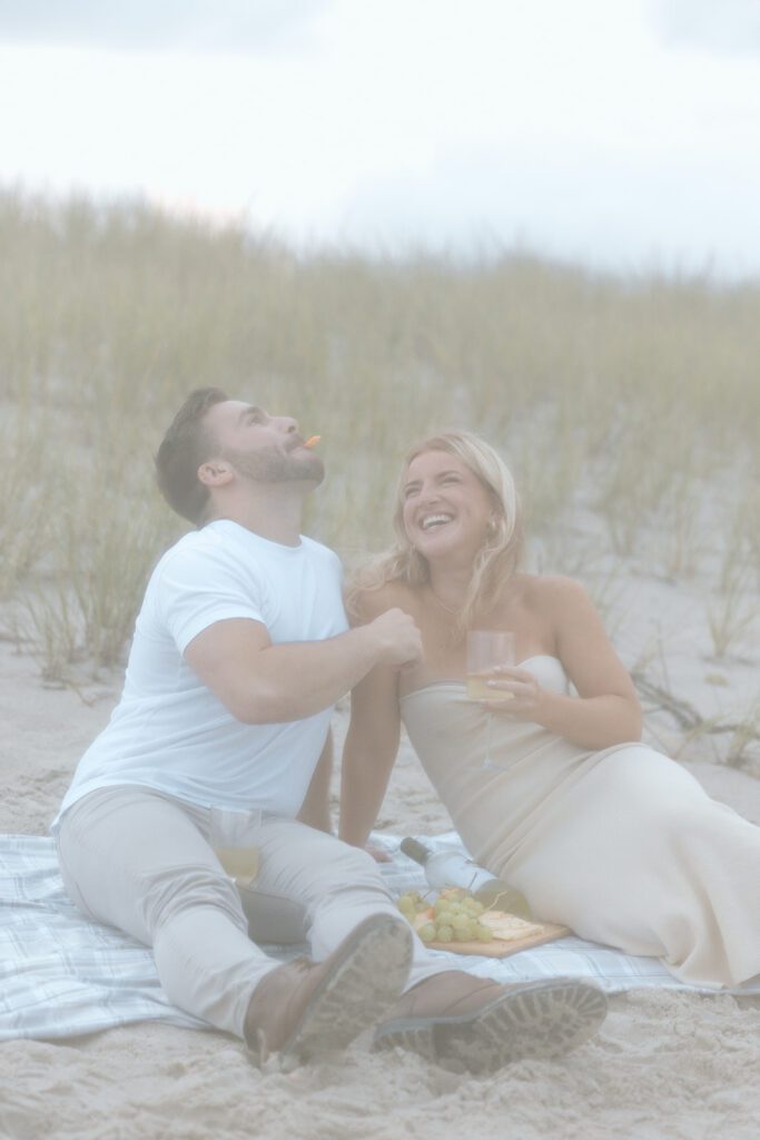 woman feeding man at beach picnic 