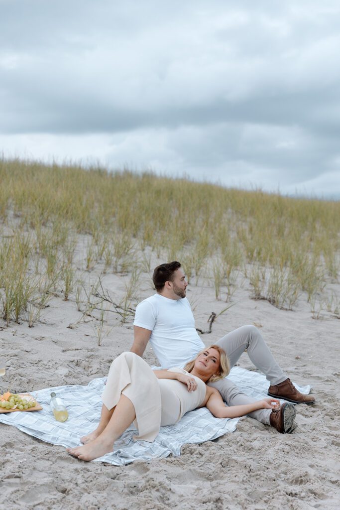 couple lounging during picnic on the beach 