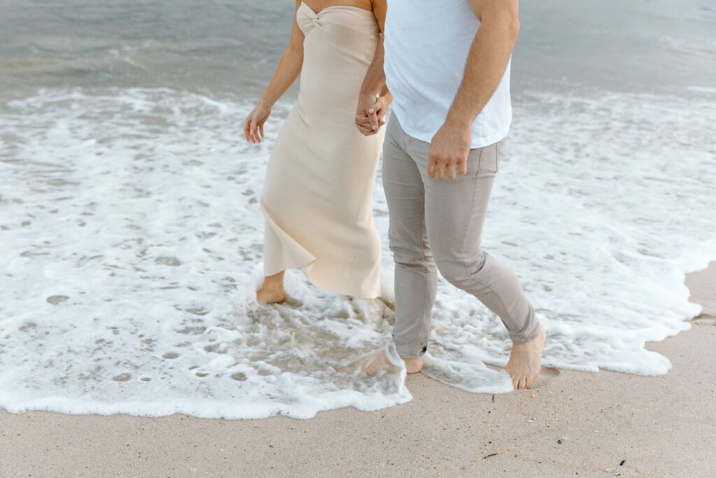 couple holding hands at the shore 