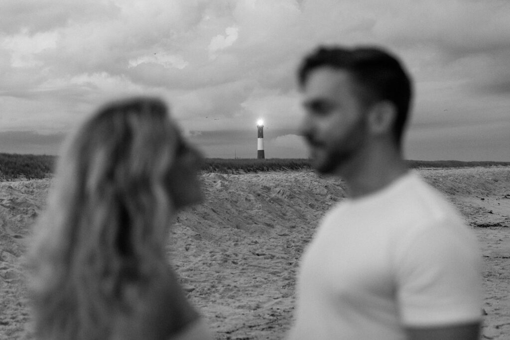 black and white picture of couple in front of a lighthouse 