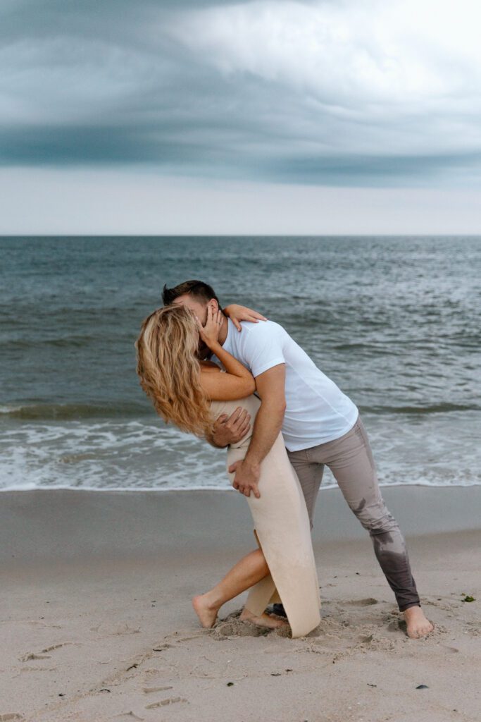 man dipping woman for a kiss on the beach 