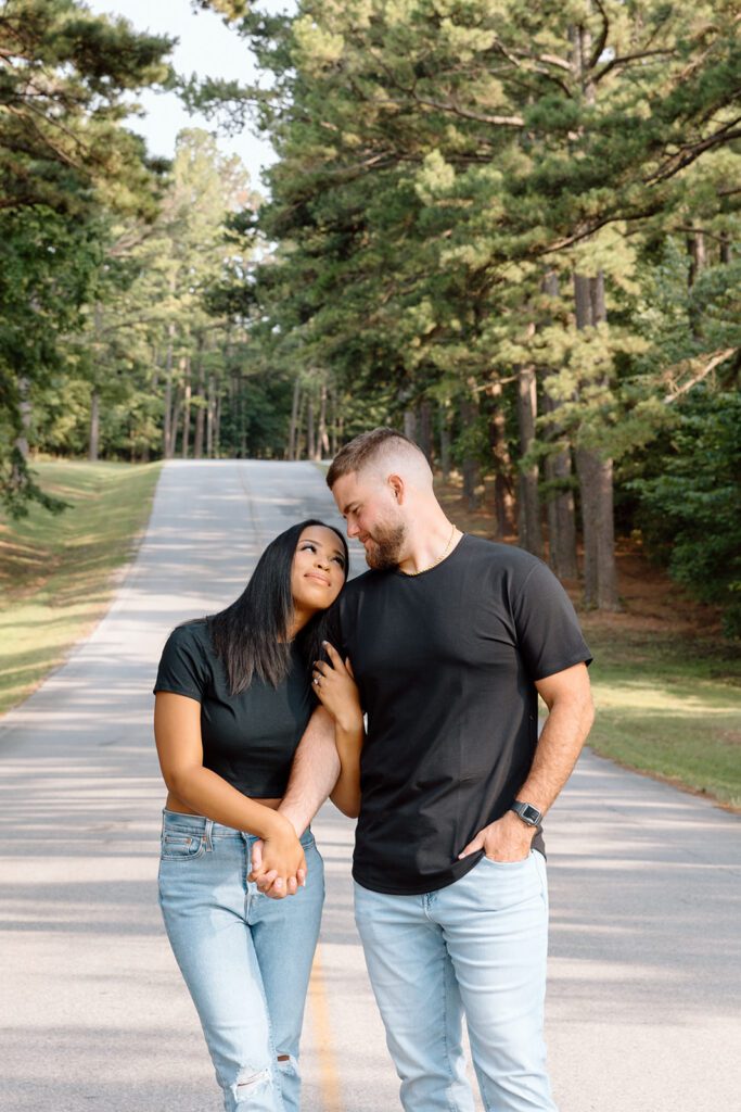 couple looks at each other in the road near forest 