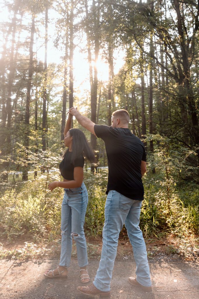 man and woman dance in the forest with jeans and black tshirts 