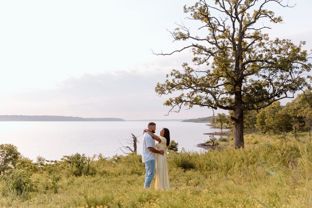 couple in prairie with lake behind for engagement picture