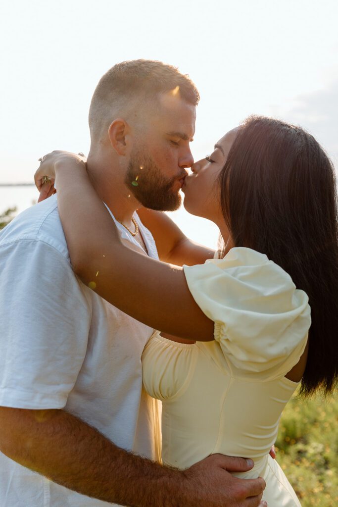 couple kisses in summer attire 