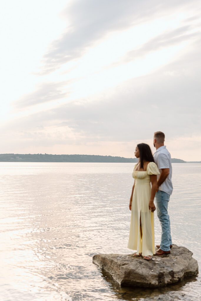 interracial couple looks over lake 