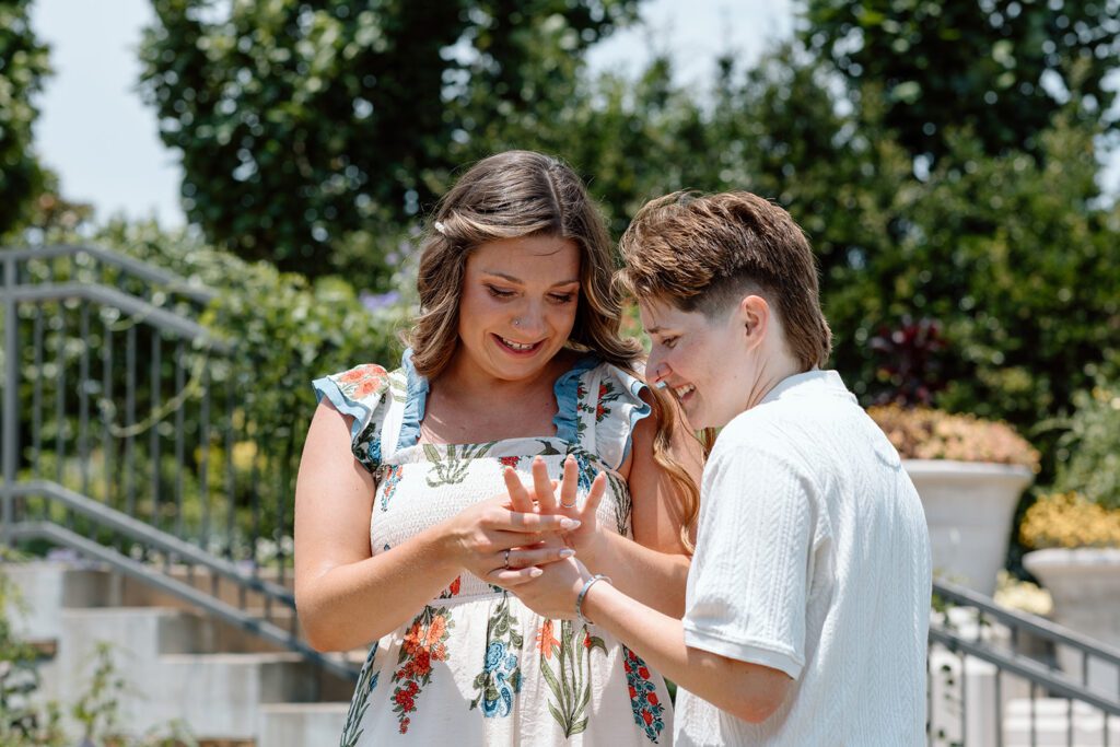 two women looking at engagement ring at queer engagement at Tulsa Botanical Garden
