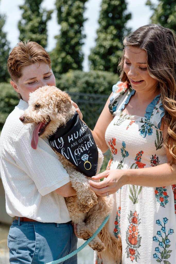 couple holds dog at queer engagement at Tulsa Botanical Garden