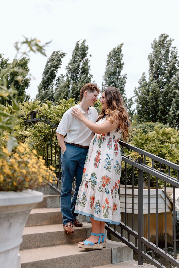 couple stares at each other on steps at queer engagement at Tulsa Botanical Garden