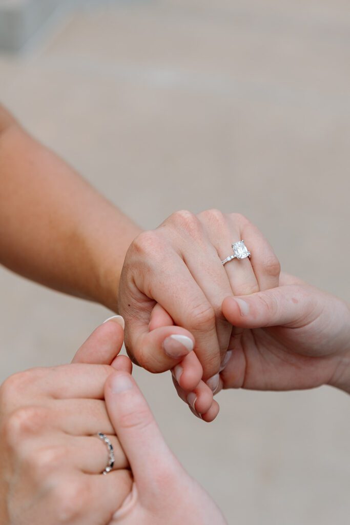 holding hands with engagement ring at queer engagement at Tulsa Botanical Garden