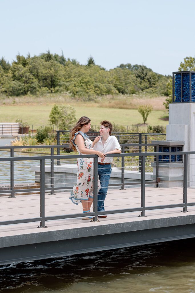 couple on dock looking at each other at queer engagement at Tulsa Botanical Garden