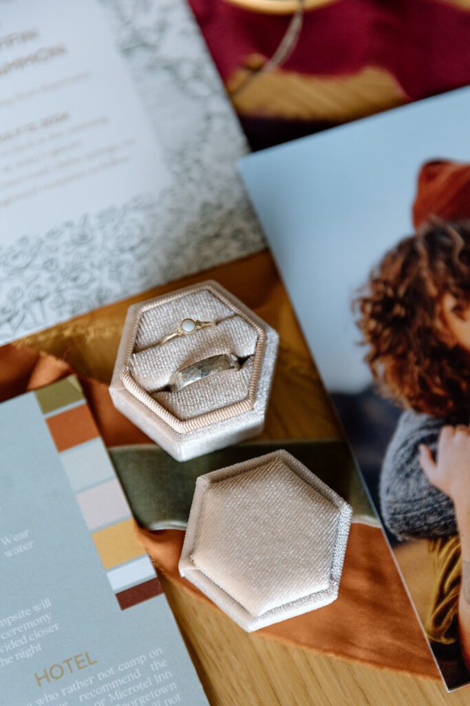 bridal ring box with his and hers on flat lay autumn colored wedding invite 