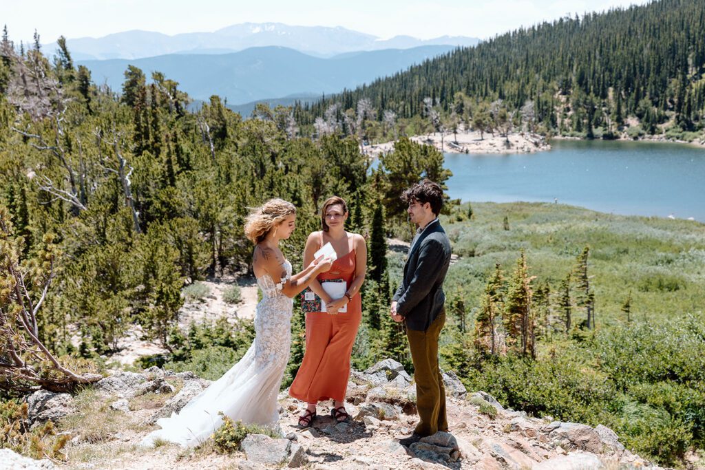 bride reads vows with St Mary's Glacier backdrop in Colorado elopement 