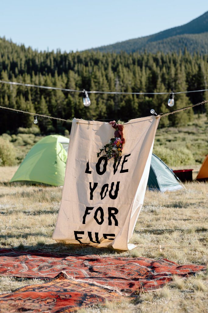 Camping reception set up with love you sign and bouquet 
