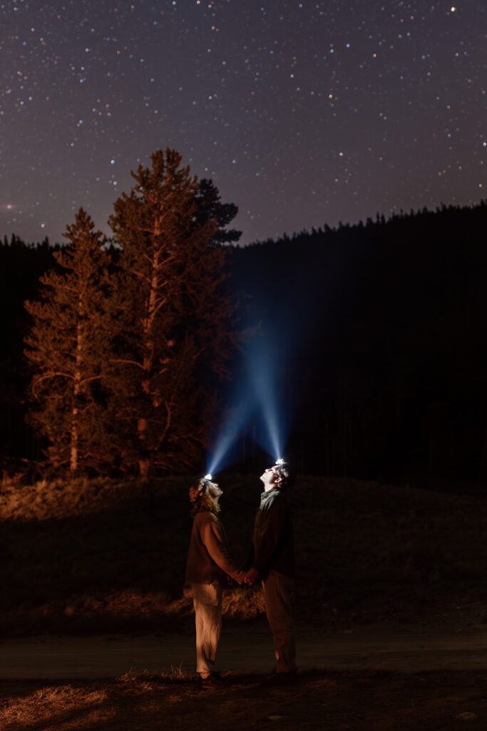 bride and groom look at milky way with headlamps at camping elopement guanella's pass 